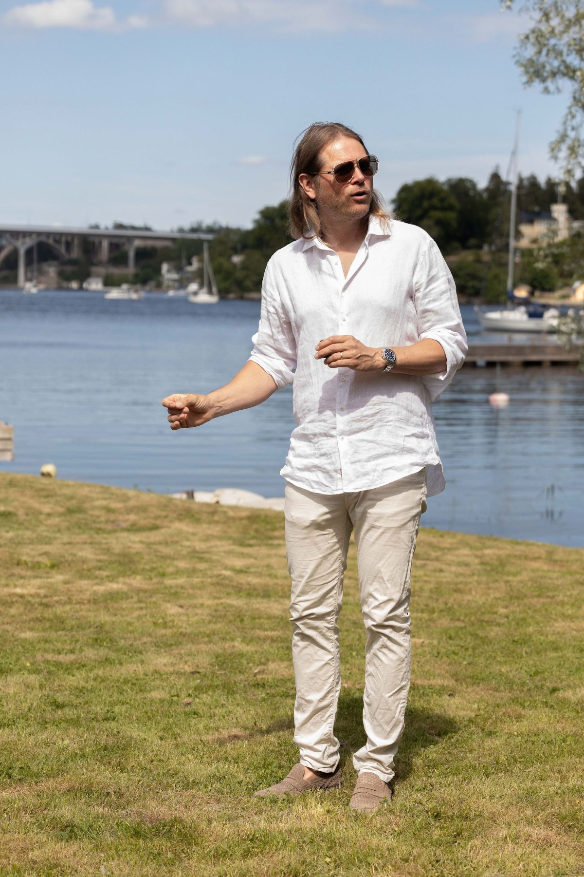 Johan Åberg talar till gästerna vid vattnet på sommarfesten